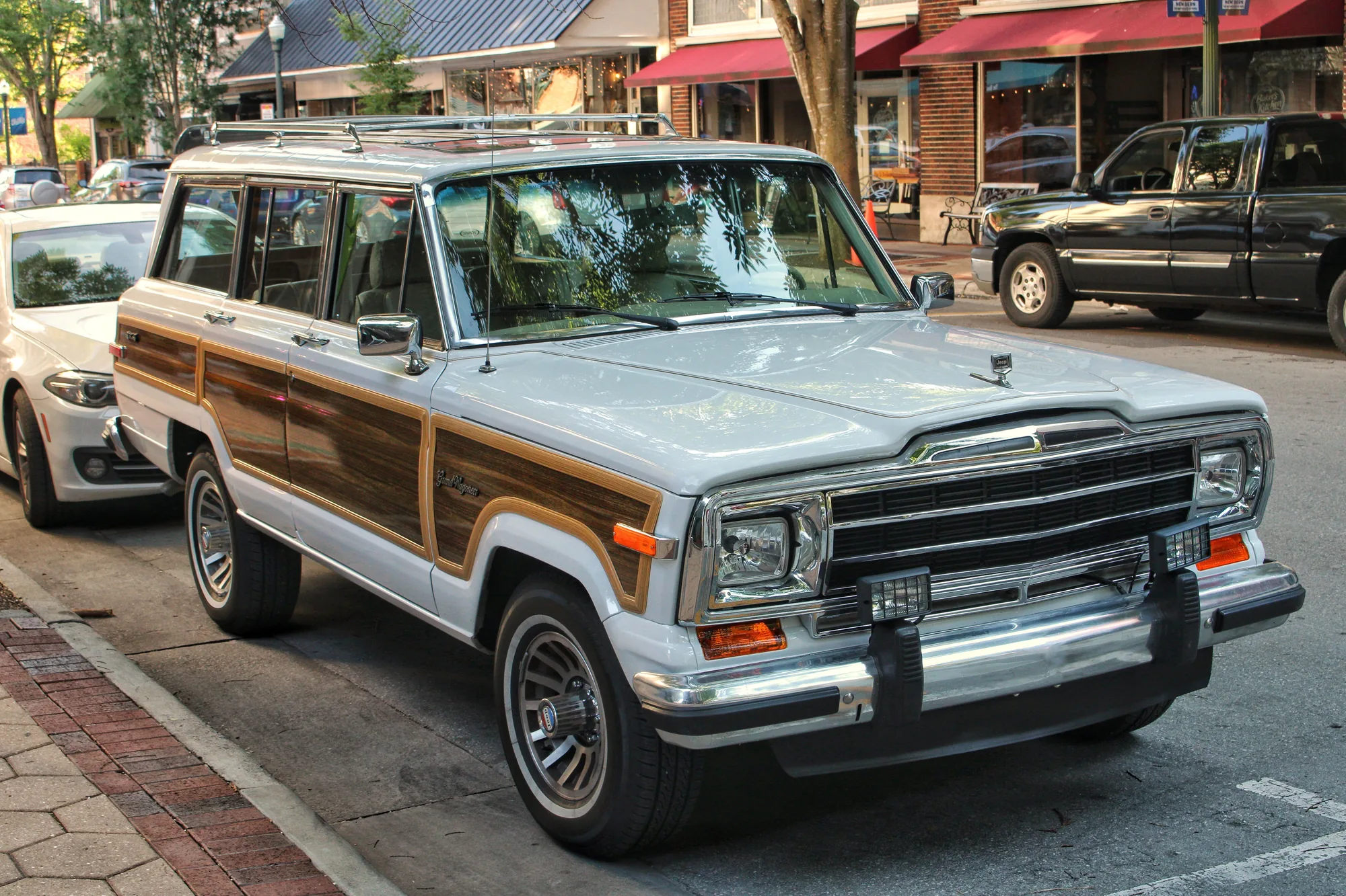Vintage Jeep Grand Wagoneer parked along a city street