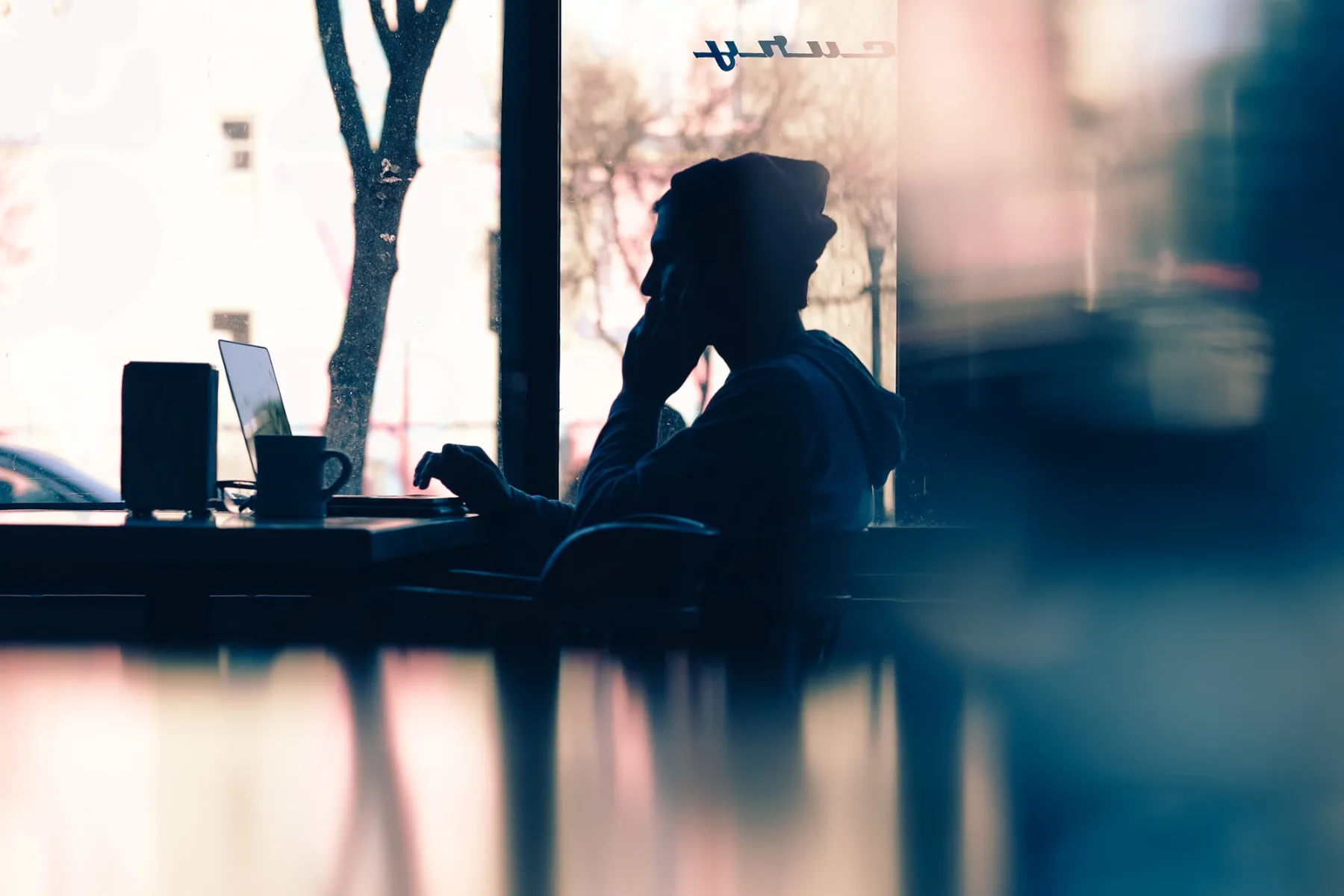 Creative professional working at a laptop near a window
